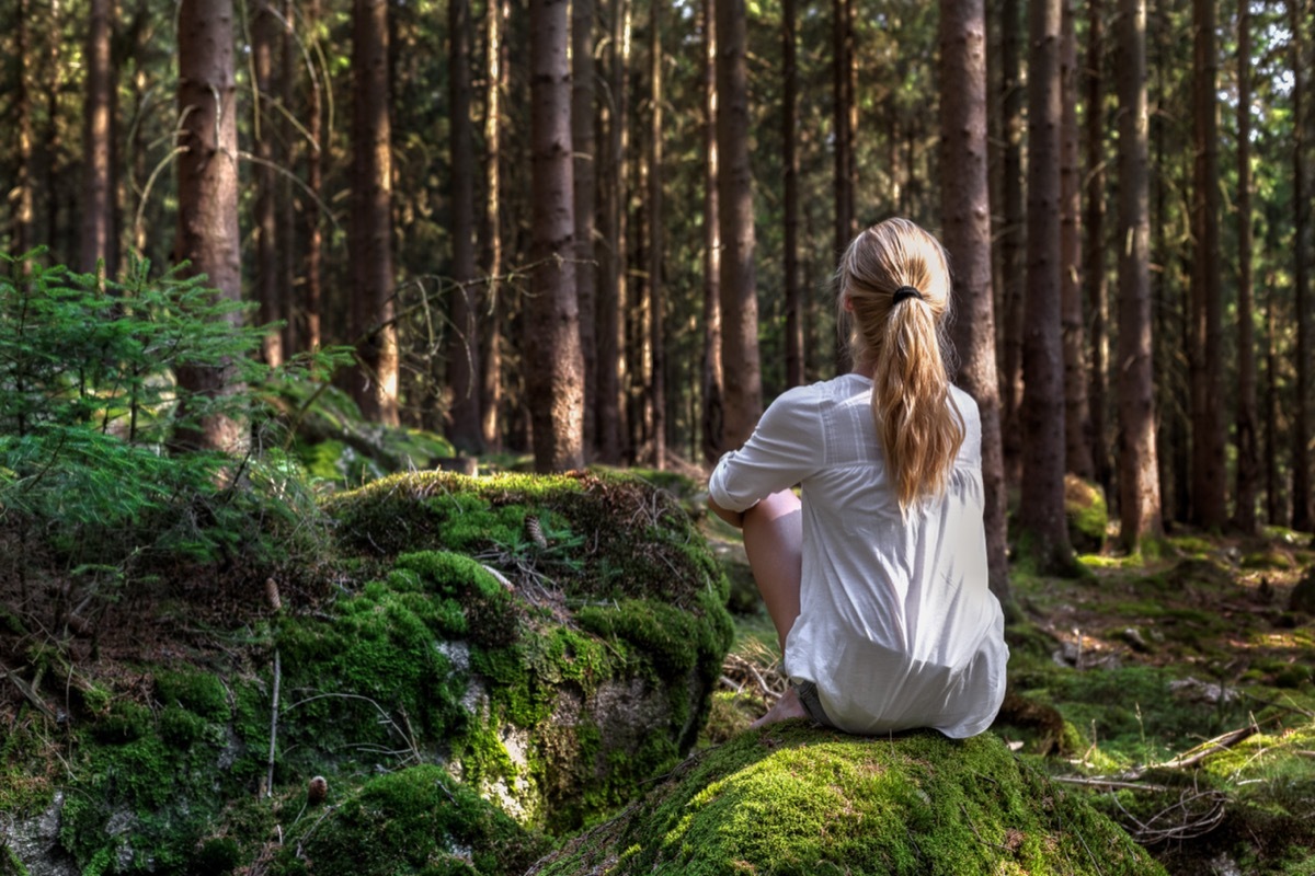 Woman sitting alone in the woods. 