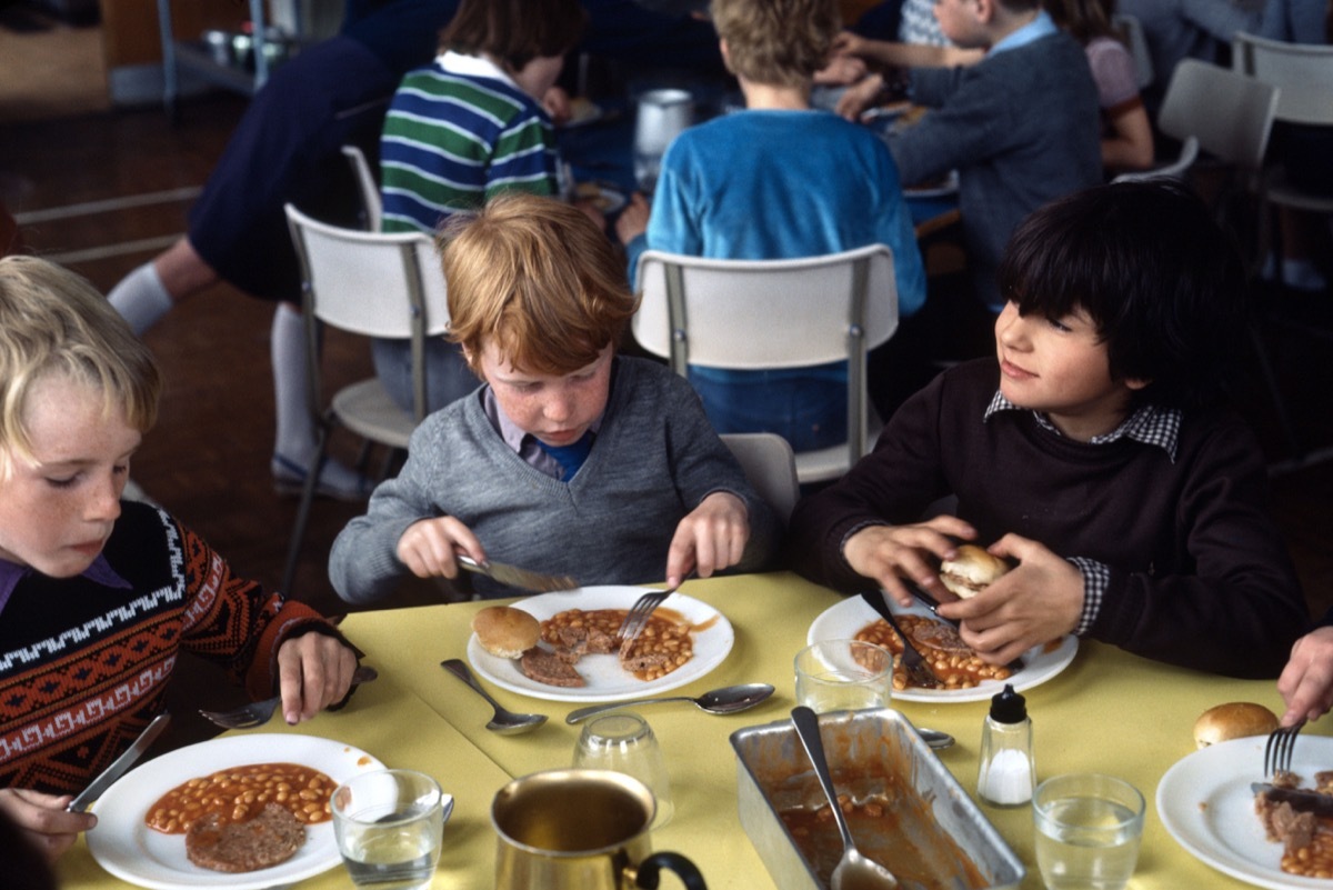 1970s historical image of school meals in primary education in the 1970's where instant food was served with very little fresh greens