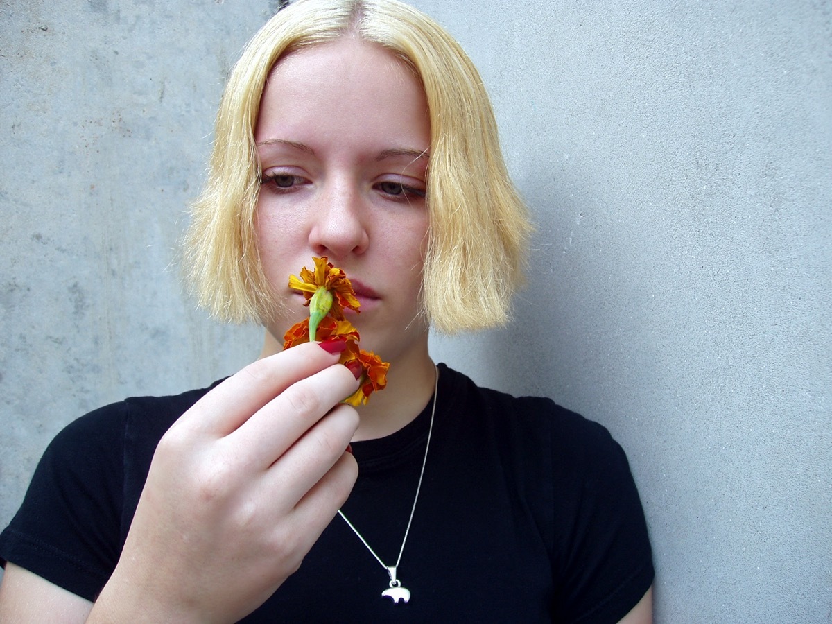 Woman smelling flower.