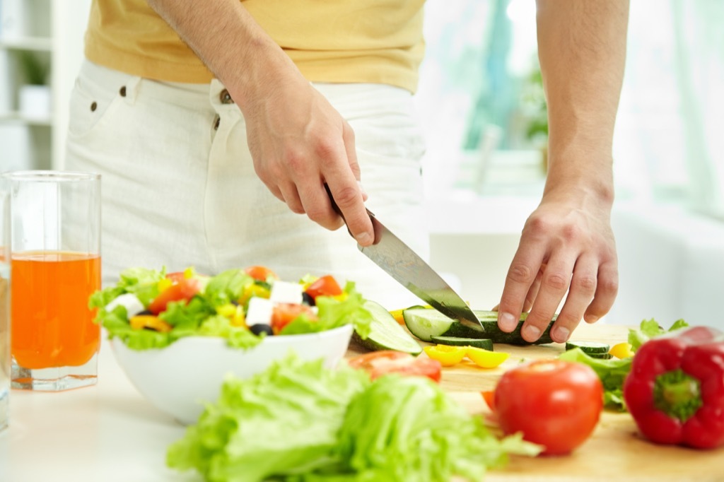 man chopping cucumbers