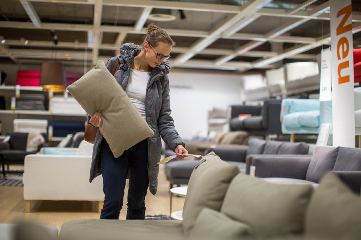 woman checks price of couch while furniture shopping