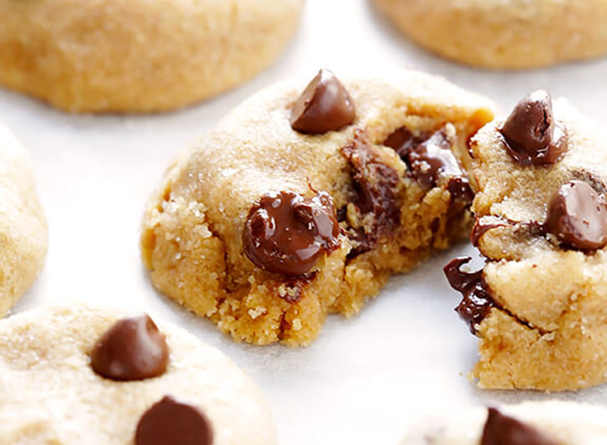 Splitting a peanut butter chocolate chip cookie on a white table