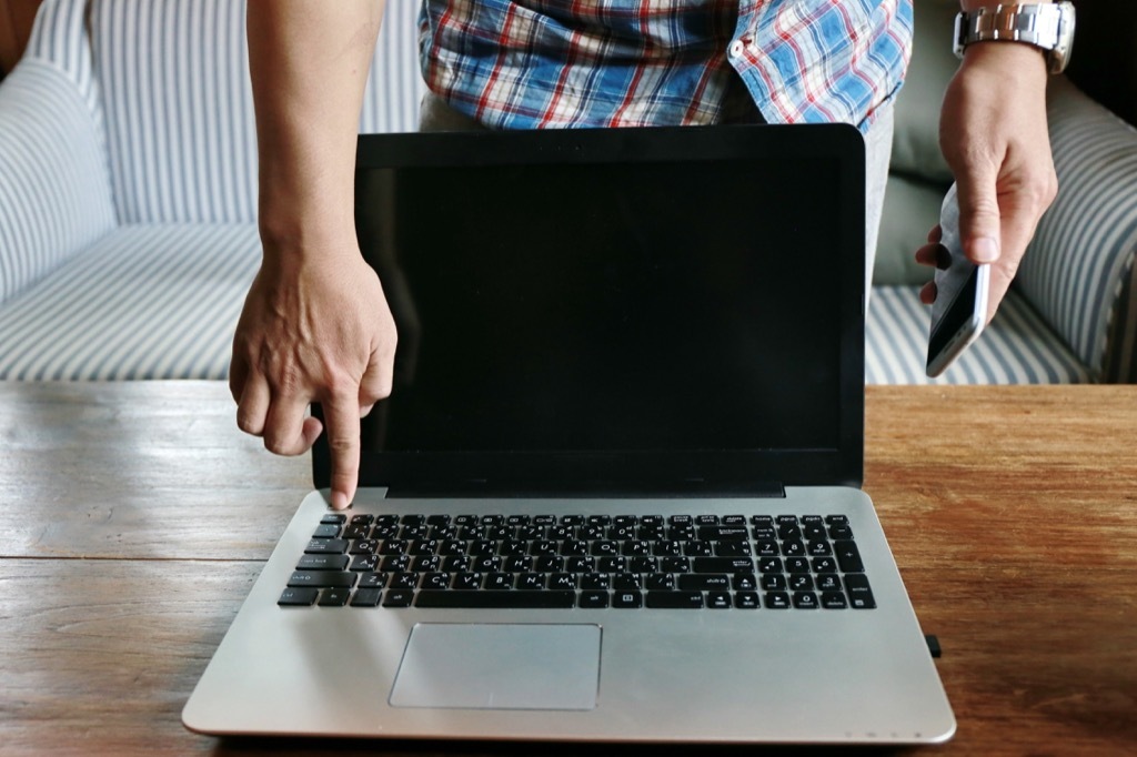 Man Powering on a Laptop Get Rid of Old Stuff