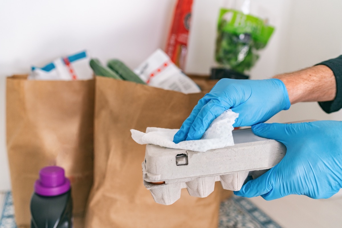 Person sanitizing grocery packages