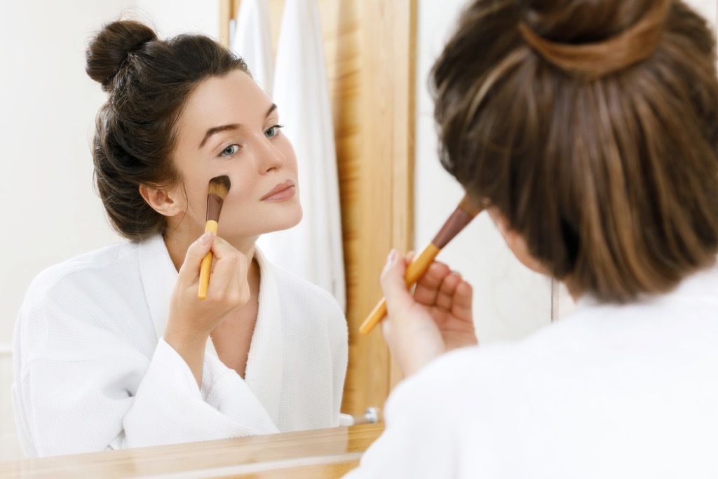 woman putting on makeup