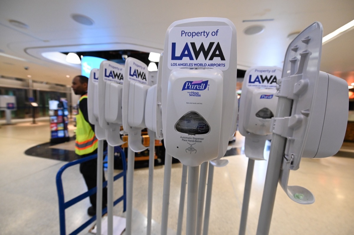 An airport employee transports mobile hand santizing stations at Los Angeles International Airport 