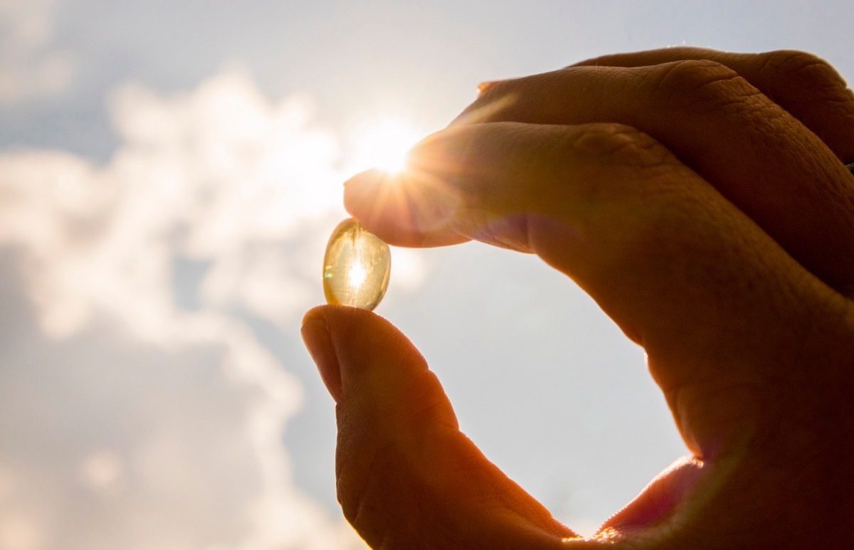 hand holding vitamin d capsule fall weather health