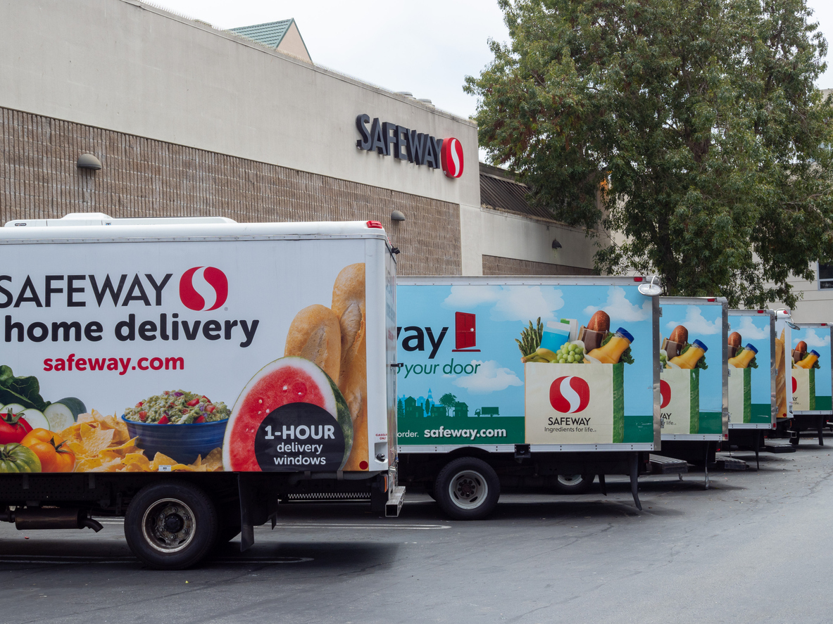 Fleet of Safeway home grocery delivery trucks outside of store location