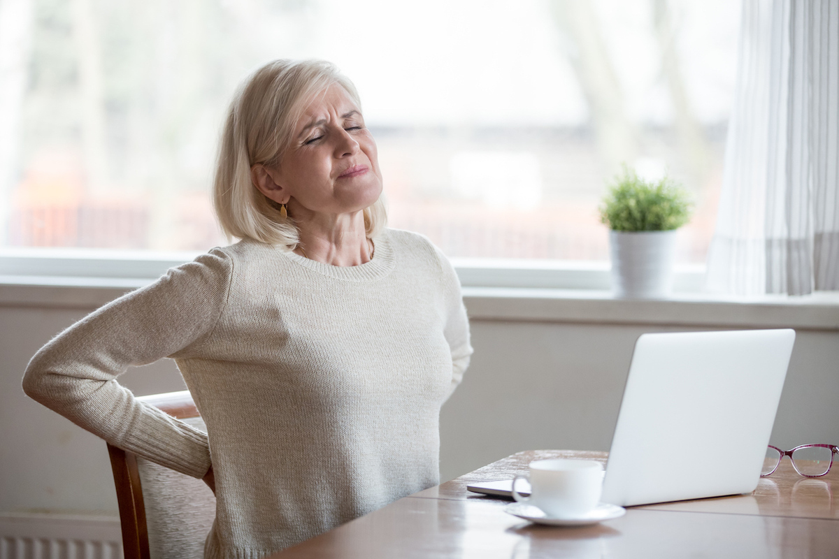 Woman sitting and feeling back pain