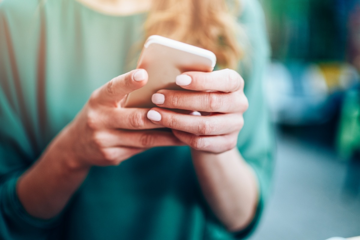 Close-up of an unrecognizable woman using smart phone