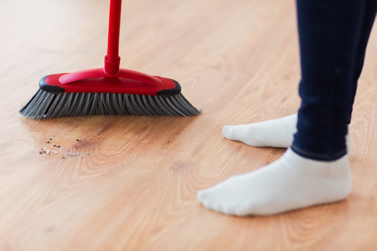 person using broom on hardwood floor, how often you should replace your cleaning supplies