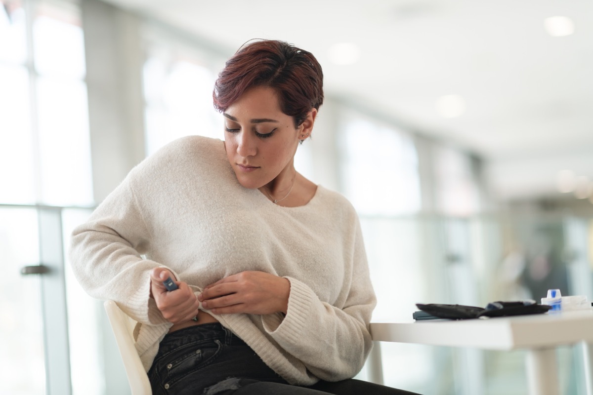 Woman using an insulin pen near her hip