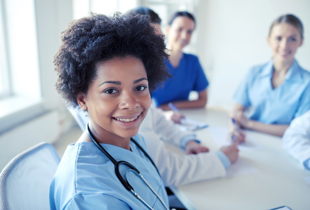 group of nurses and doctors sitting in scrubs at table, school nurse secrets