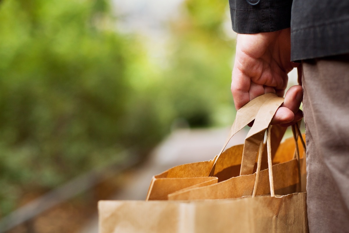 man carrying paper shopping bags