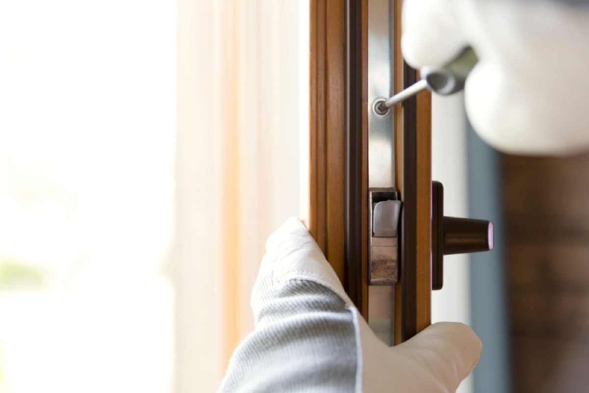 man in gloves replacing wood door