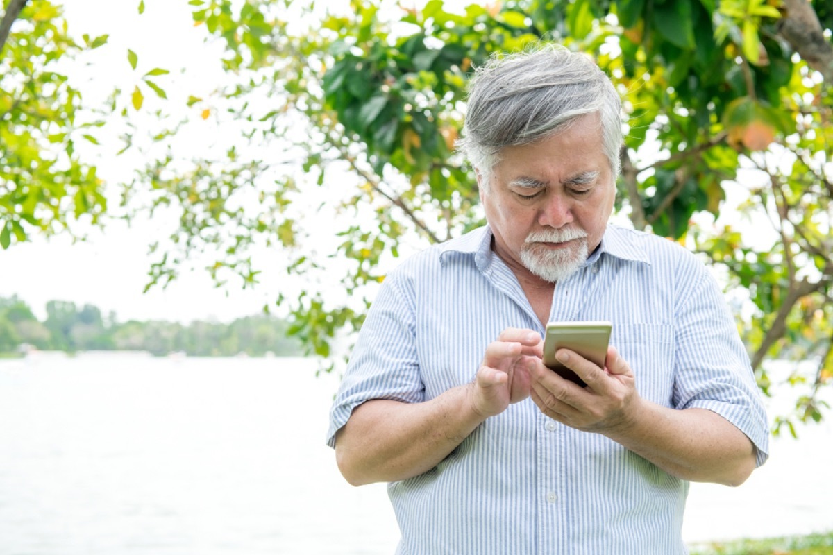 senior asian man confused by cell phone