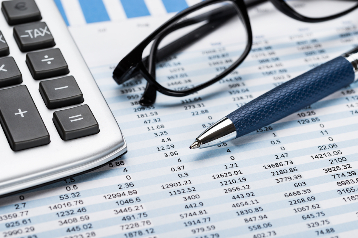 Close-up Of A Calculator With Pen And Eyeglasses On Data Sheet