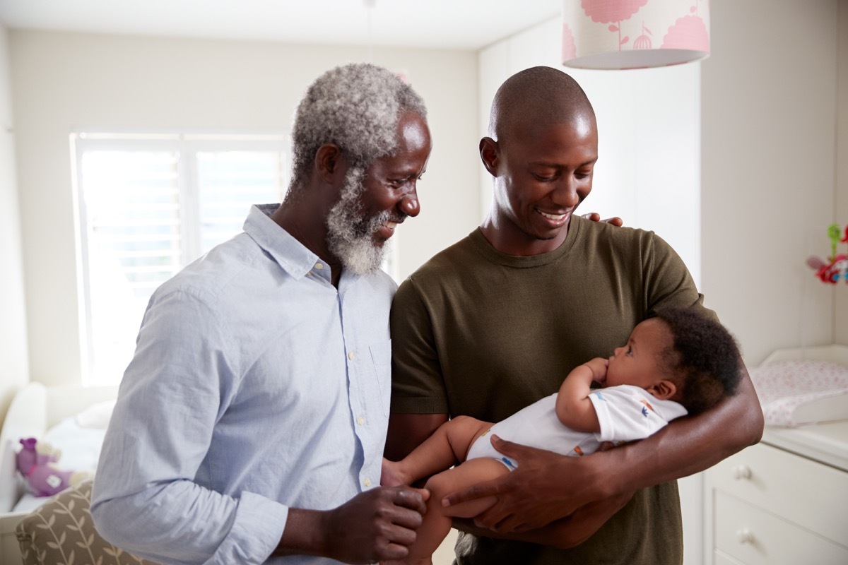 Proud grandparent looking and grandbaby with son