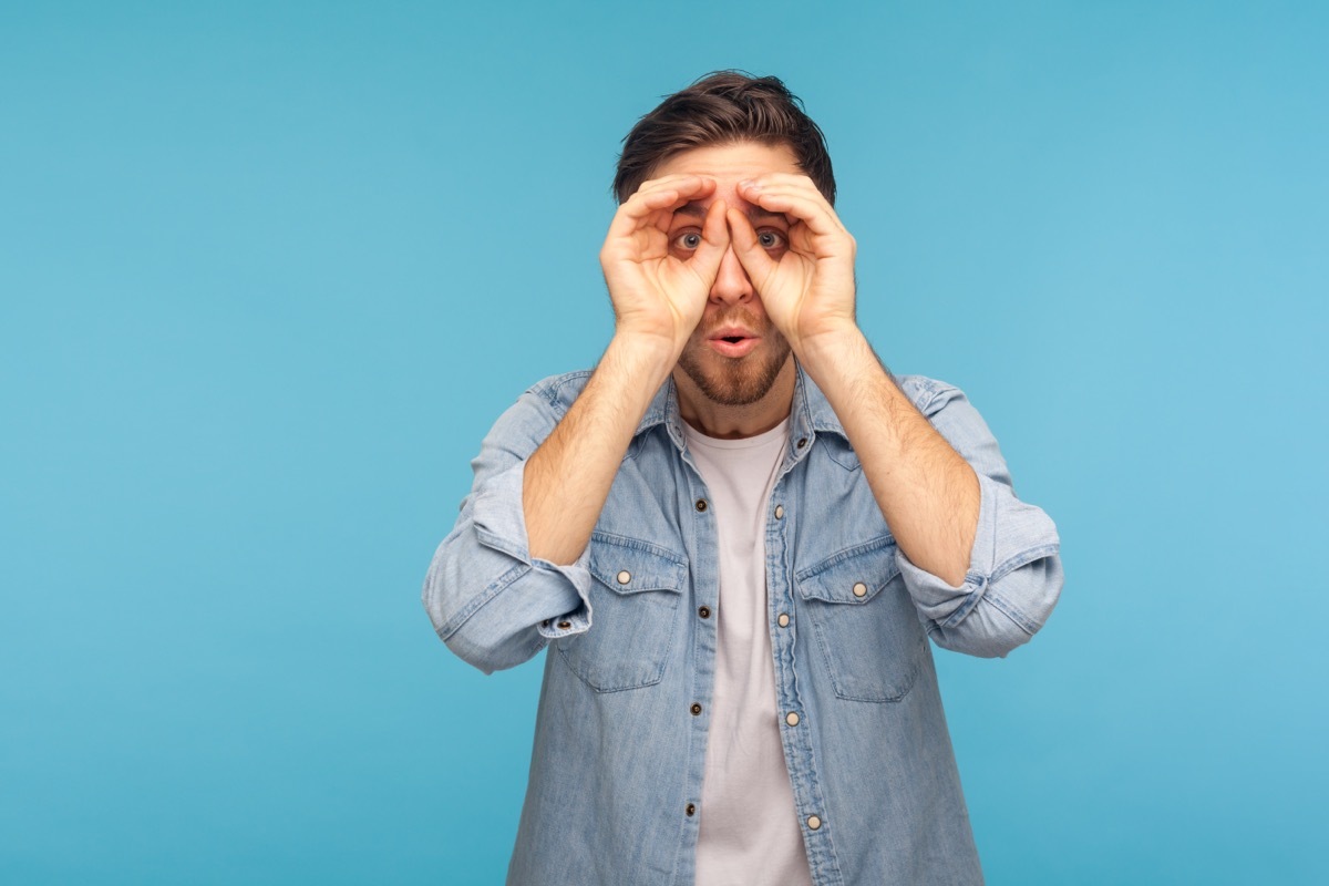 man pretending he is looking through a telescope