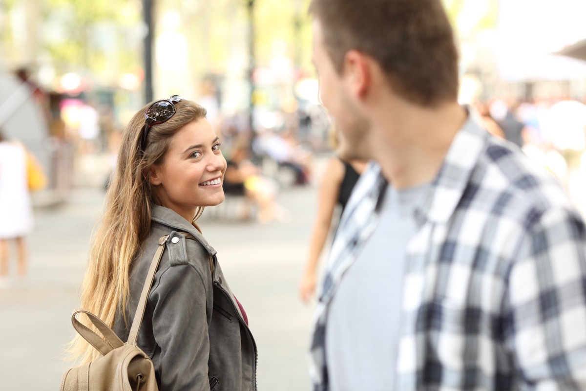 man and woman bumping into each other on the street