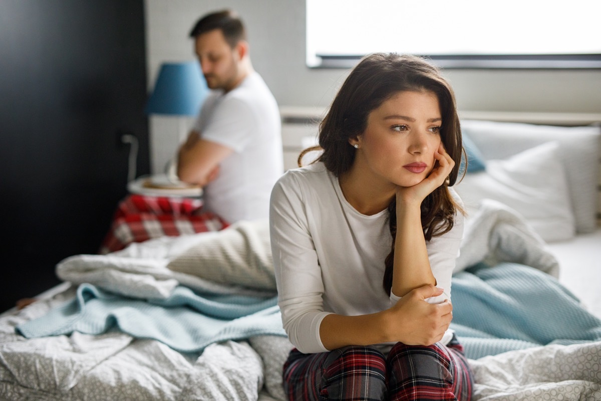 Sad couple sitting on bed after having a quarrel