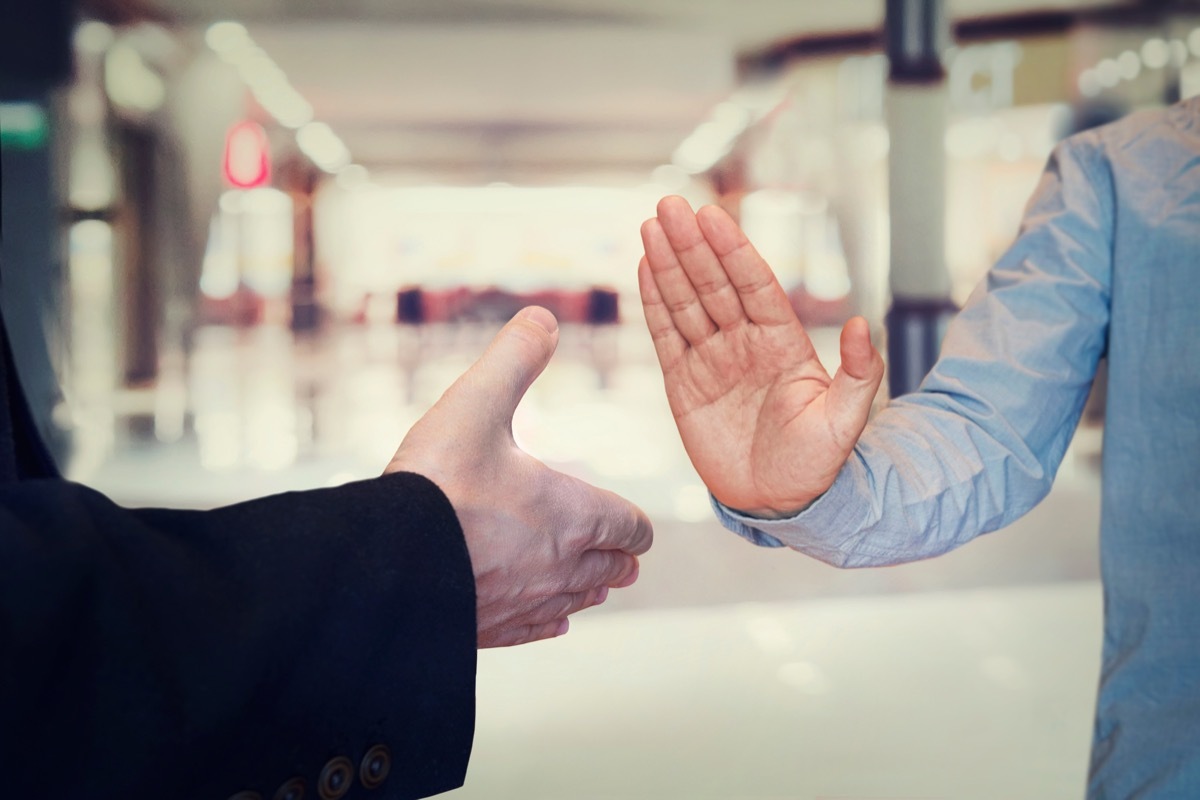 man refusing hand shake with her friend to protect herself from coronavirus in public areas. Prevention of fight against pandemic. Non-contact greeting. Quarantine methods to control spread of virus.