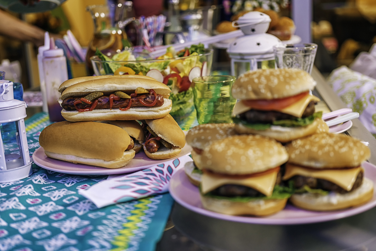 Preparing homemade burgers with tomatoes, onions and salad