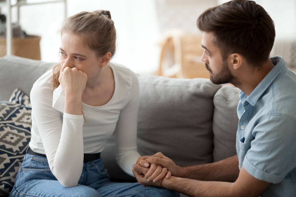 husband holding wife's hand while upset