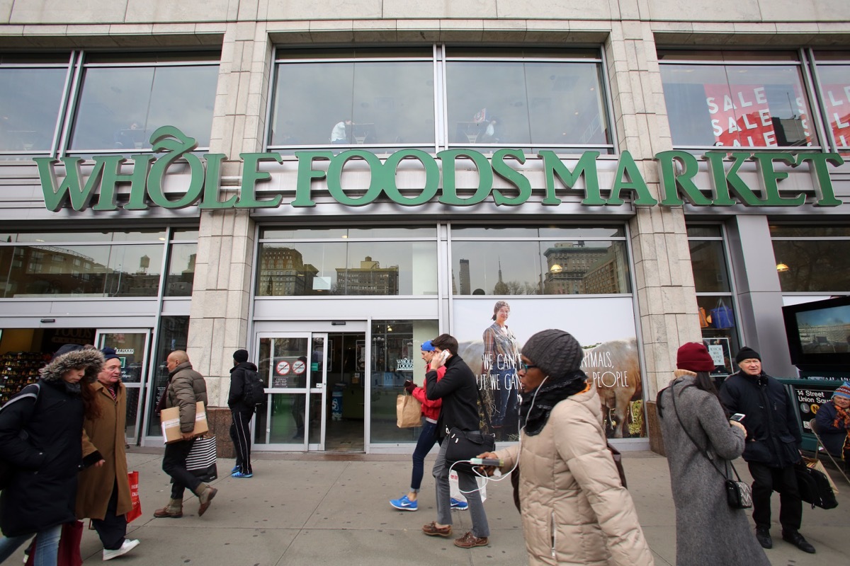 people walk past whole foods market