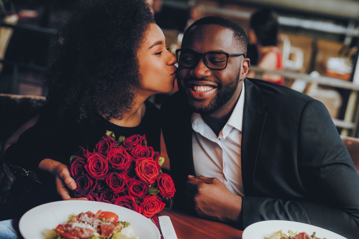 Black couple at restaurant with roses