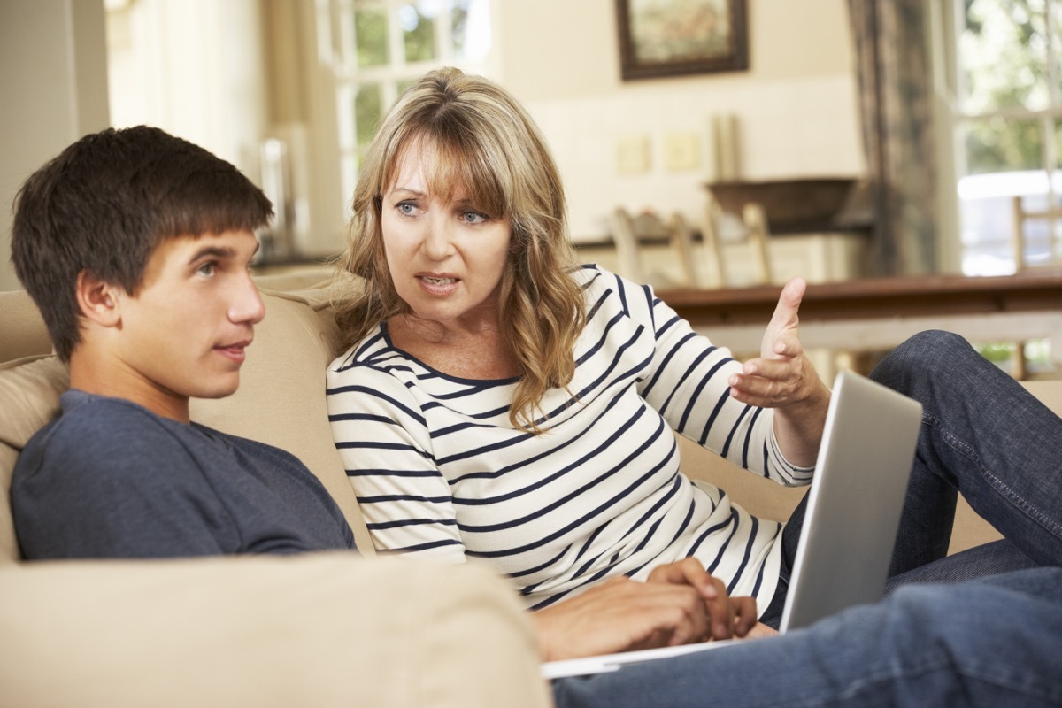 white mother and son arguing on couch