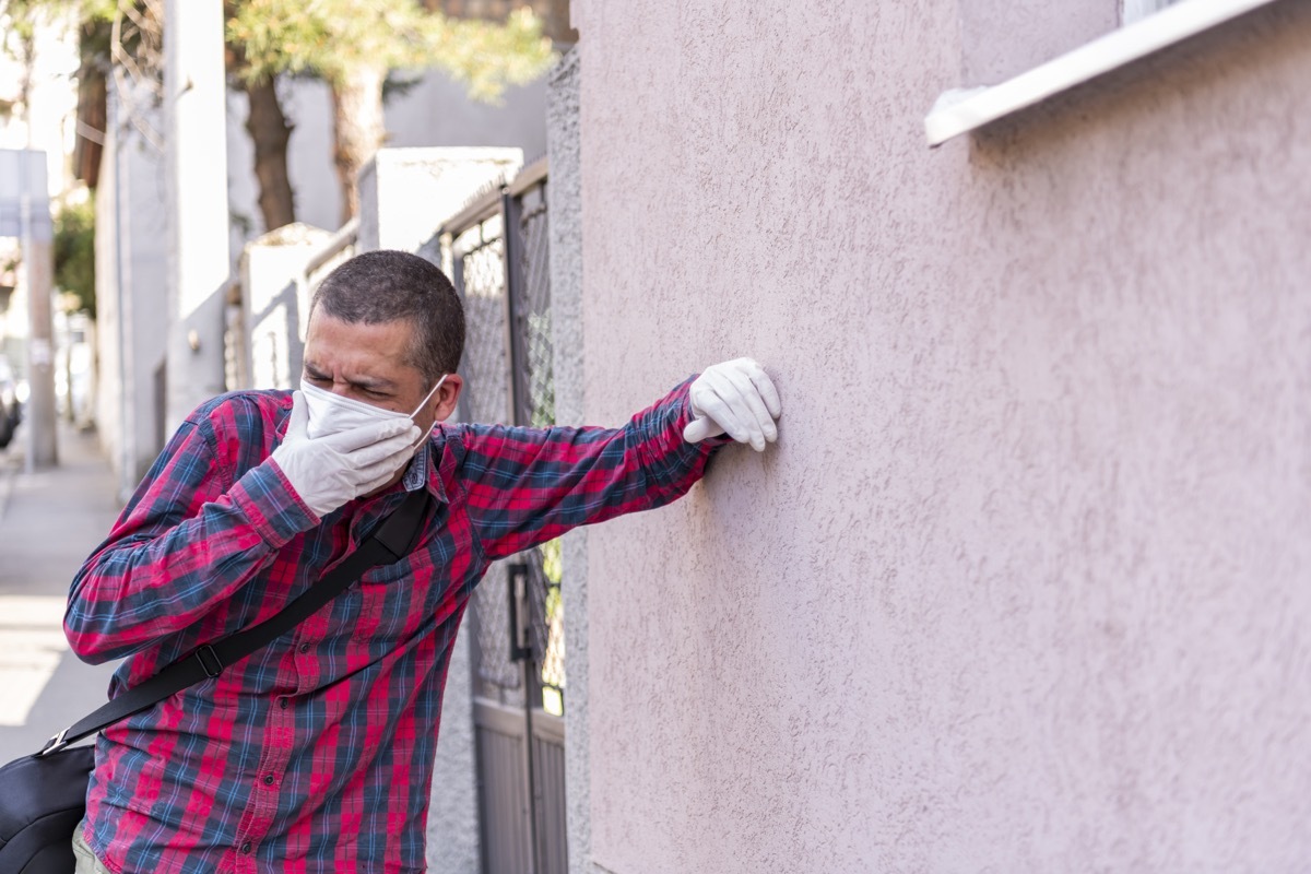 Mature Man with Protective Gloves and Face Mask is Feeling a Symptoms of Coronavirus During a City Walk. Business Person with a Pain in the Chest.