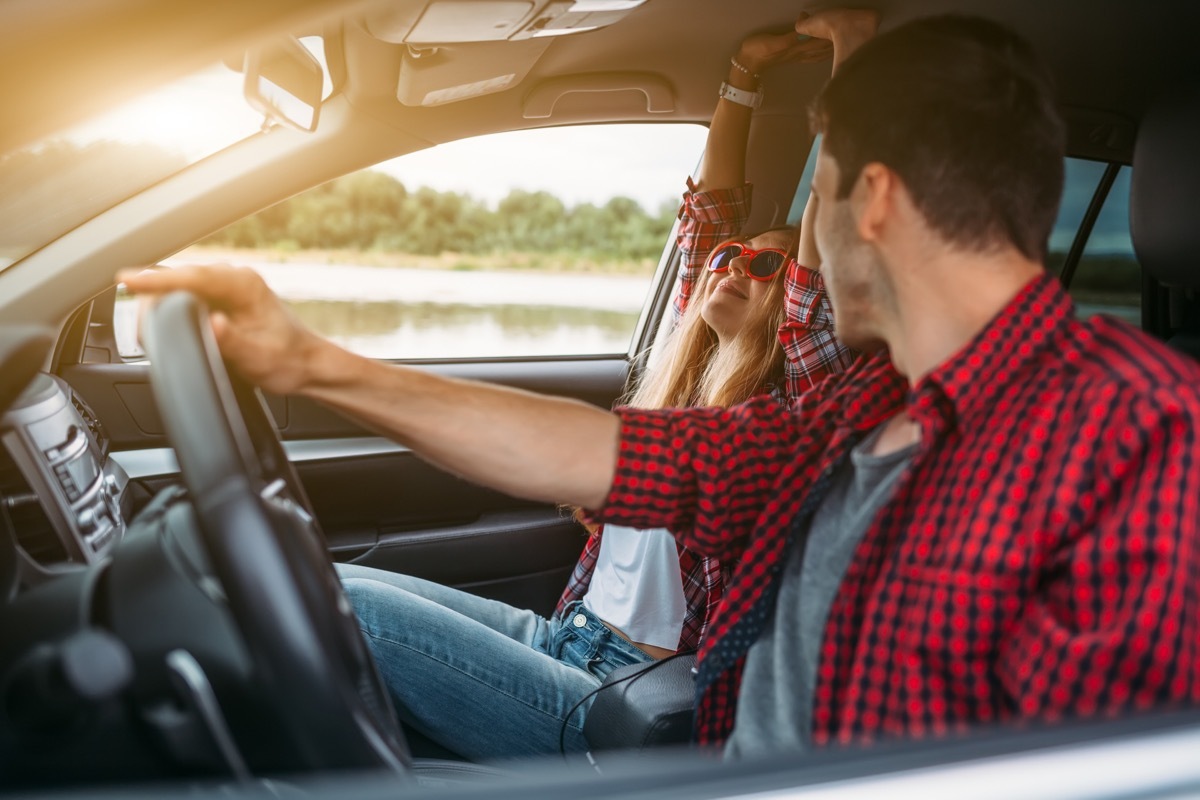 Couple on road trip listening to music together