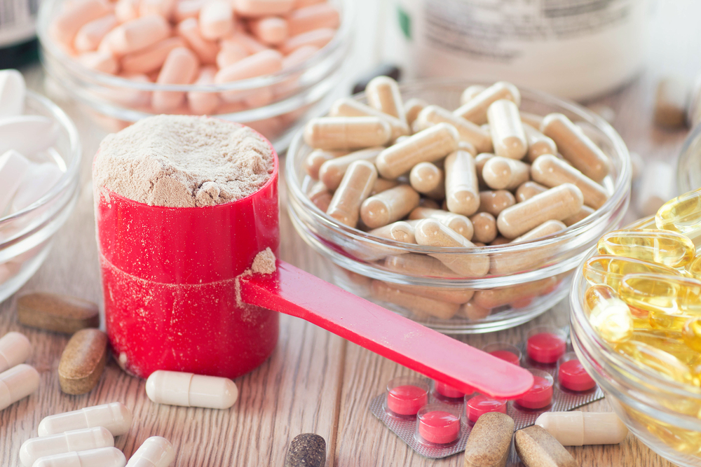 Dietary and athletic supplement pills and powder sitting on a tabletop