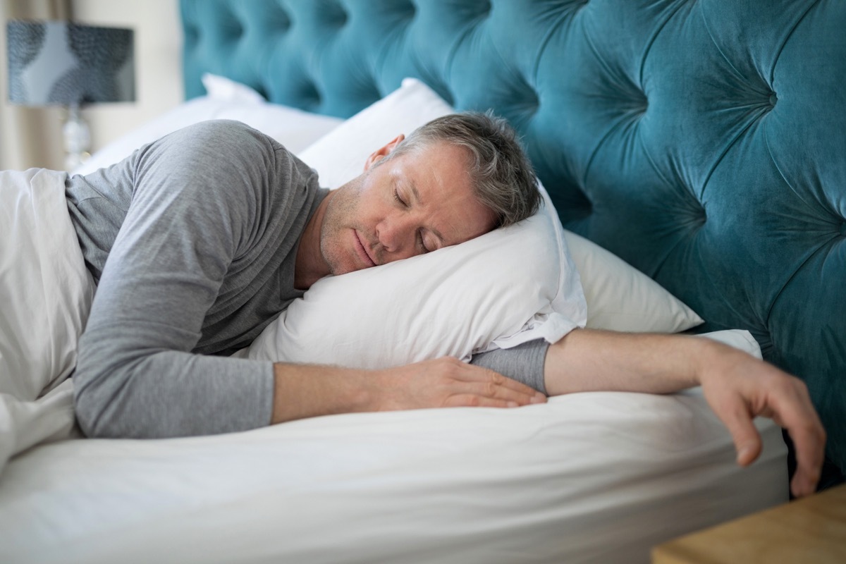 Man sleeping during daylight in his bed